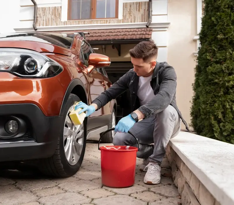Lavage auto à domicile Bazincourt-sur-Epte : professionnel intervenant sur un véhicule